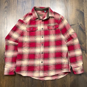May include: A red and cream plaid flannel shirt with a brown corduroy collar. The long-sleeved shirt has two chest pockets and a button-down front. The shirt is made of a soft, warm material.