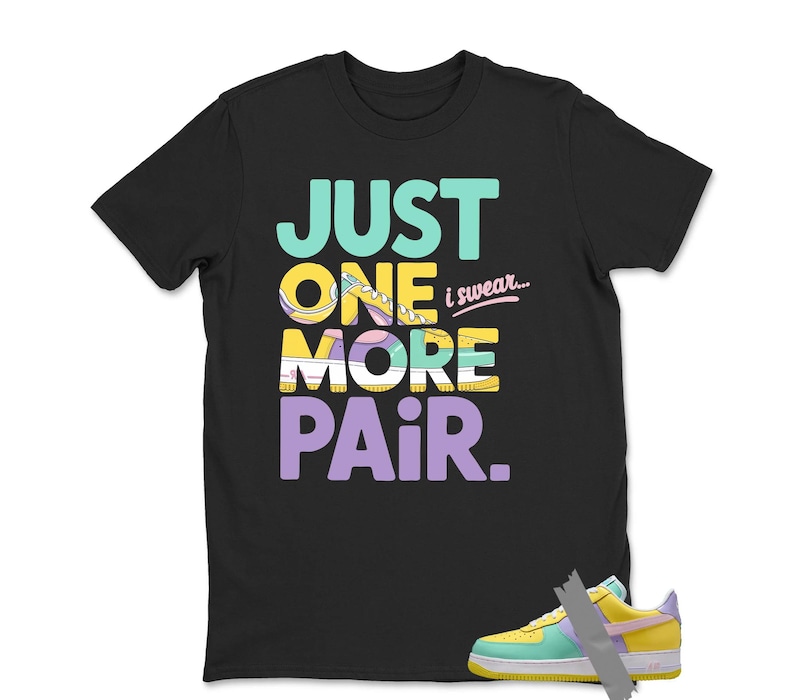 May include: Black t-shirt with the text "JUST ONE MORE PAIR i swear..." in teal, yellow, white, and purple. A colorful sneaker is visible at the bottom right. The shirt is a casual wear item.
