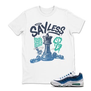 May include: White t-shirt with a graphic of a chess queen and pawns in blue and black, with the text "SAYLESS" above. A pair of white, blue, and green sneakers are in the lower right corner.