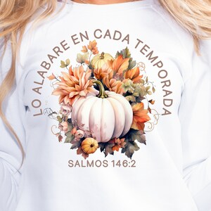 May include: White sweatshirt with a fall-themed design featuring a pumpkin, flowers, and leaves. The text "LO ALABARE EN CADA TEMPORADA" is written in a circle around the design. The text "SALMOS 146:2" is written below the design.