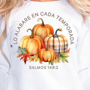 May include: White sweatshirt with a watercolor illustration of pumpkins and fall leaves. The text "LO ALABARE EN CADA TEMPORADA" is written in a circle around the pumpkins. The text "SALMOS 146:2" is written below the pumpkins.