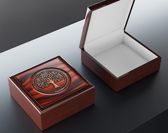 May include: A square wooden box with a dark reddish-brown wood grain finish. The lid features a circular inlay with a tree design and Hebrew text. A second identical box is shown open, revealing a plain white interior lining and a hinged lid.