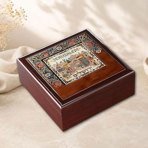 May include: A square dark wood box featuring a central ceramic tile inlay. The tile displays a colorful illustration of the Jerusalem cityscape with the text JERUSALEM and Hebrew characters, surrounded by a decorative floral border of pomegranates.