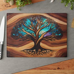 May include: A rectangular wooden cutting board featuring a central tree illustration with dark brown branches and roots set against a swirling background of vibrant turquoise, blue, and purple hues, with a white knife positioned to the left side.