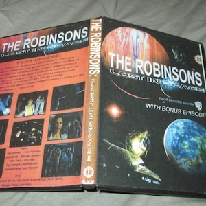 May include: DVD case with a black background and a red and orange planet. The text on the case reads "The Robinsons: Lost in Space" and "Pilot Episode with Bonus Episode".