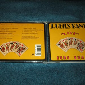 May include: A yellow CD case with a picture of playing cards and the text "J. Geils Band Live Full House". The back of the case lists the songs on the CD.