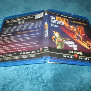 May include: Blue and black DVD case with a title of "The Devil's Partner" and a subtitle of "Creature From The Haunted Sea". The case features a scene from the movie with a woman riding a creature in the water.