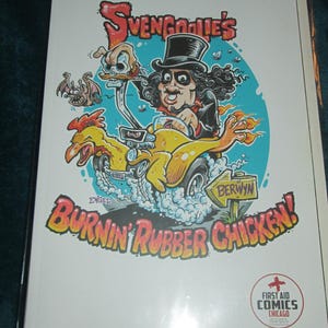 May include: A comic book cover featuring a cartoon of a man in a top hat driving a yellow chicken-shaped car. The title reads "SvenGoolie's Burnin' Rubber Chicken!" with the First Aid Comics Chicago logo.