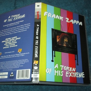 May include: A VHS video cassette with a colorful cover featuring Frank Zappa and the text "A Token of His Extreme".