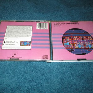 May include: A pink CD case with a blue and white image of a computer circuit board. The case has the text "Computer Experiments" and "Synergy" printed on the front.