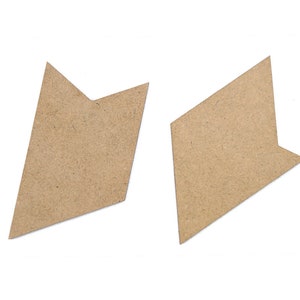 Op de afbeelding: Twee bruine kartonnen puzzelstukken in de vorm van pijlen. De stukken zijn uitgesneden en hebben een ruwe textuur.