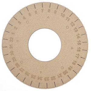 以下が含まれることがあります： 縁に1から32までの数字が印刷された木製の円。円はリングのサイズを測定するために使用されます。