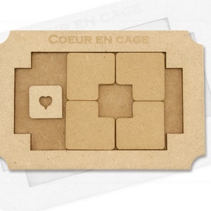 Könnte beinhalten: Ein Holzpuzzle mit dem französischen Spruch "Coeur en Cage". Das Puzzle zeigt ein Herz in der Mitte und ein Gitter aus Quadraten drumherum.