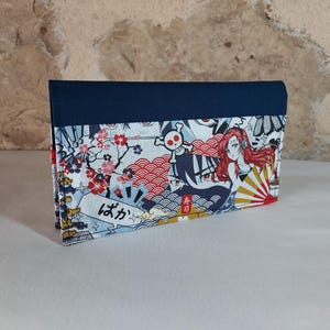 May include: A rectangular wallet with a navy blue flap. The main body features a colorful anime-style print with characters, cherry blossoms, and Japanese text. The wallet is made of fabric and sits on a white surface.