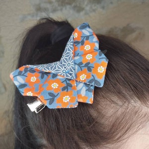 Origami butterfly barrette with orange flowers, blue background and Japanese patterns