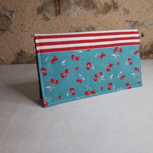 Porta chequera de cereza con fondo turquesa