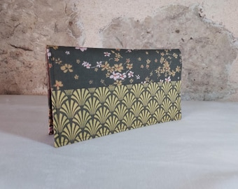 May include: A green and yellow fabric wallet with a floral pattern on the top half and a geometric pattern on the bottom half.
