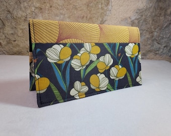 May include: A black fabric wallet with a floral pattern. The wallet has a yellow and brown geometric pattern on the top flap.