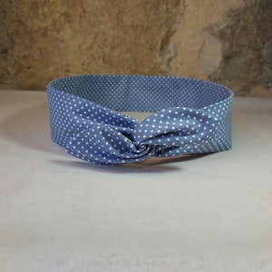 May include: A blue headband with white polka dots tied in a knot.