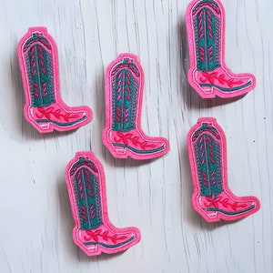 May include: Five pink embroidered iron-on patches of cowboy boots with green and pink details.