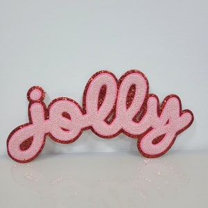 May include: Pink glitter "jolly" word cutout with red glitter outline.