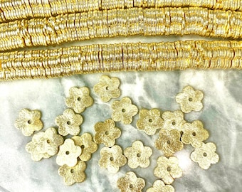 May include: Gold metal beads and flower-shaped charms. The beads are small and round, and the charms are five-pointed stars with a hole in the center.