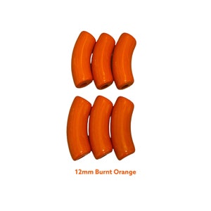 May include: Six burnt orange curved beads, each 1.2cm in length, arranged in two rows of three. The beads have a glossy finish and a cylindrical shape with a slight curve. Text at the bottom reads "12mm Burnt Orange".