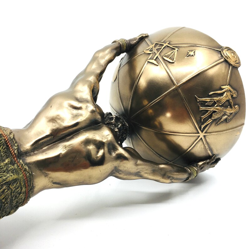 May include: Bronze sculpture of a muscular figure holding up a globe. The globe is decorated with symbols and designs.