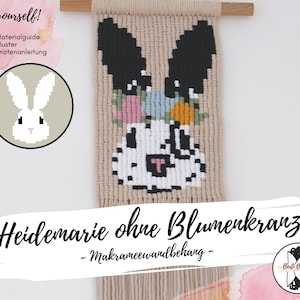 Könnte beinhalten: Ein beige-weißer Makramee-Wandbehang mit einem schwarz-weißen Hasendesign. Der Hase trägt eine rosa, blaue und orangefarbene Blumenkrone. Der Text "Heidemarie ohne Blumenkranz - Makrameewandbehang -" befindet sich am unteren Rand des Bildes.