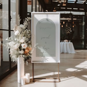 May include: A white sign with a light blue background and an arch shape at the top. The sign says "All along there was some invisible string tying you to me" and "Sarah & Chase" with the date "October 23rd, 2021".