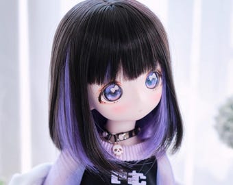 May include: A doll with black hair, purple streaks, and large blue eyes. The doll wears a black top with white text and a skull choker. The doll's skin is pale with rosy cheeks, and the hair is styled in a bob.