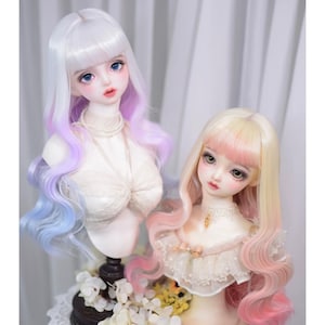 May include: Two doll busts with long, wavy hair. One has white hair that fades to purple and blue. The other has blonde hair that fades to pink. Both dolls have detailed facial features, including large eyes and delicate makeup.