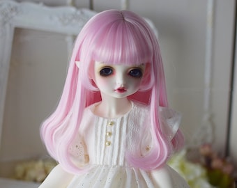 May include: A pink doll wig with long, straight hair and a side-swept fringe. The wig is styled in a layered, wavy style.