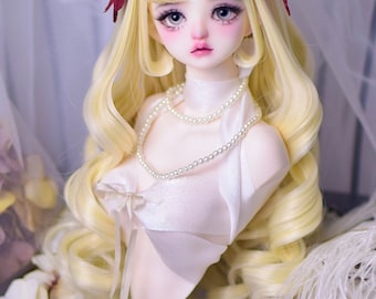 May include: A blonde doll with a white dress and a pearl necklace. The doll is wearing a red bow on each side of her head. The doll is on a wooden stand.