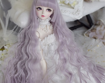 May include: A long, wavy, lavender wig with bangs for a doll. The wig is styled with loose waves and a straight fringe.