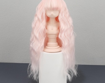 Può includere: Parrucca per bambola rosa chiaro con capelli lunghi e ondulati e frangia. La parrucca è esposta su una testa di manichino con un collo a forma di colonna classica, posta su un supporto cilindrico bianco. I capelli hanno una consistenza morbida e fluida.