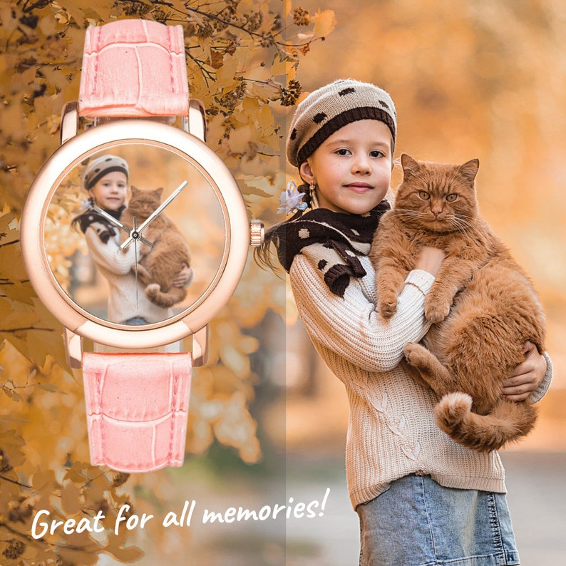May include: A pink wristwatch with a round face featuring a photo of a young girl holding a ginger cat. The watch has a rose gold case and a pink leather strap.