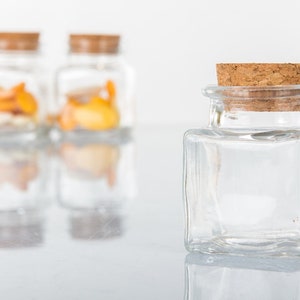 Square jars in transparent glass with cork stopper for confetti holders for wedding place cards