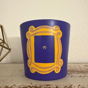 May include: A white ceramic mug with a black handle and the text "But First, Coffee" in a bold, black font. The mug is set against a neutral background, highlighting its simple design.