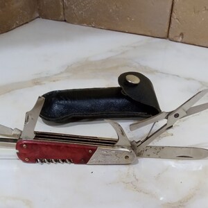 Antique folding knife in a black case.Multifunctional miniature knife with a red bakelite insert on the handle.Rare knife.Made in the 1970s.