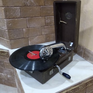 Grammofono portatile antico in una custodia in pelle marrone. Grammofono portatile vintage per dischi in vinile. Fonografo retrò URSS 1956
