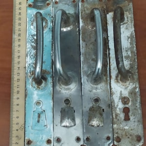 Vintage metal door handles. Large rustic pens. Farmer&#39;s house. Rustic style. 1940s. Overhead handles on the door leaf.