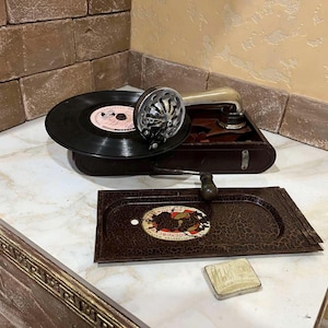 Vintage portable gramophone in metal.Vintage mini gramophone for vinyl records.retro phonograph.Recording vinyl records in the USSR 1940s