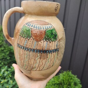 A jug with a handle made of living clay in beige color. Traditional old Ukrainian jug hand painted. Jug for milk. Flower vase.