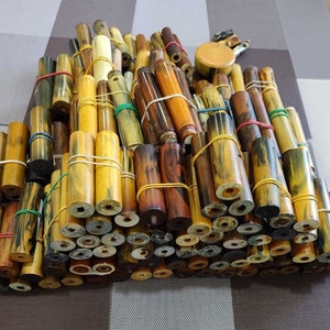 May include: A large pile of colourful, wooden, and patterned pen blanks. The blanks are arranged in a random pattern and are ready to be turned into pens.