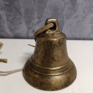 Vintage bronze bell with inscriptions.Ancient bronze bell with a beautiful old patina.Solid brass bells. Antique metal bell with a hole.