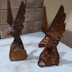 Antique vintage figurines of birds carved from wood.Sculpture of an Eagle on a rock.The art of woodcarving.Statue of a bird on a rock. Gift