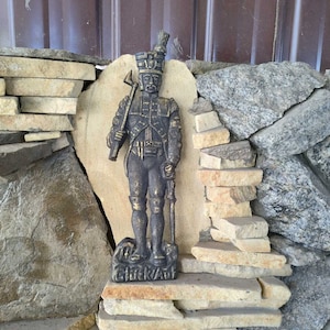 Antique metal statue of a soldier. Human figurine. Metal panel on the wall. 1940s. Home wall decor.