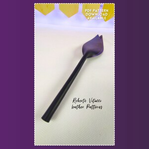 May include: A black leather working tool with a leaf-shaped head and a long handle. The tool is set against a white background. Text on the image reads "PDF PATTERN DOWNLOAD AVAILABLE" and "Roberto Vitucci leather Patterns".