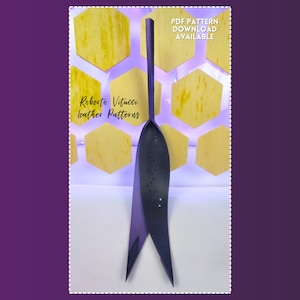 May include: A dark gray leather pattern tool with a long handle and a pointed, leaf-like blade. The tool has small holes along the blade. Text on the image reads "Roberto Vitucci leather Patterns" and "PDF Pattern Download Available."